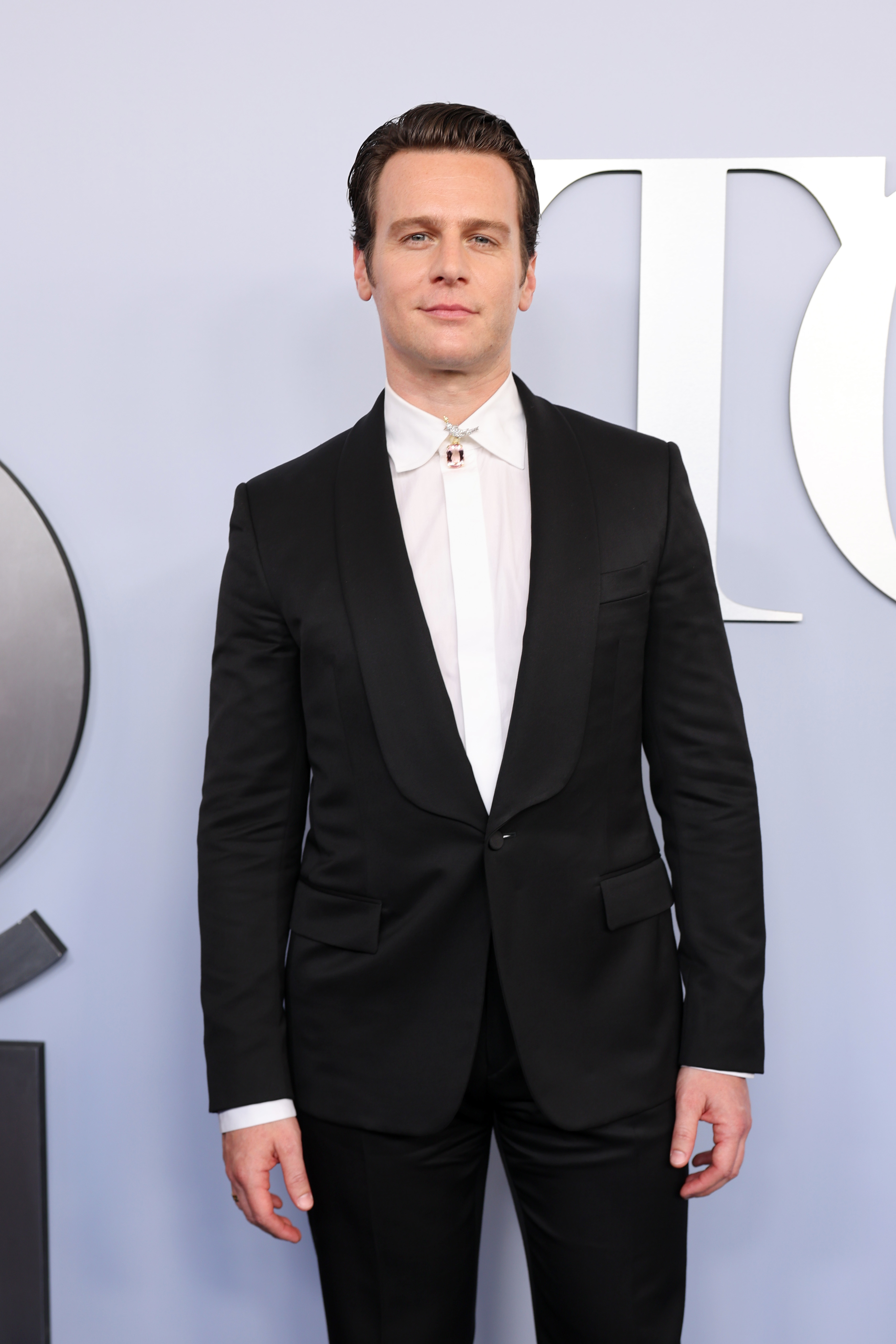 Jonathan Groff in a black suit jacket and white dress shirt at a formal event