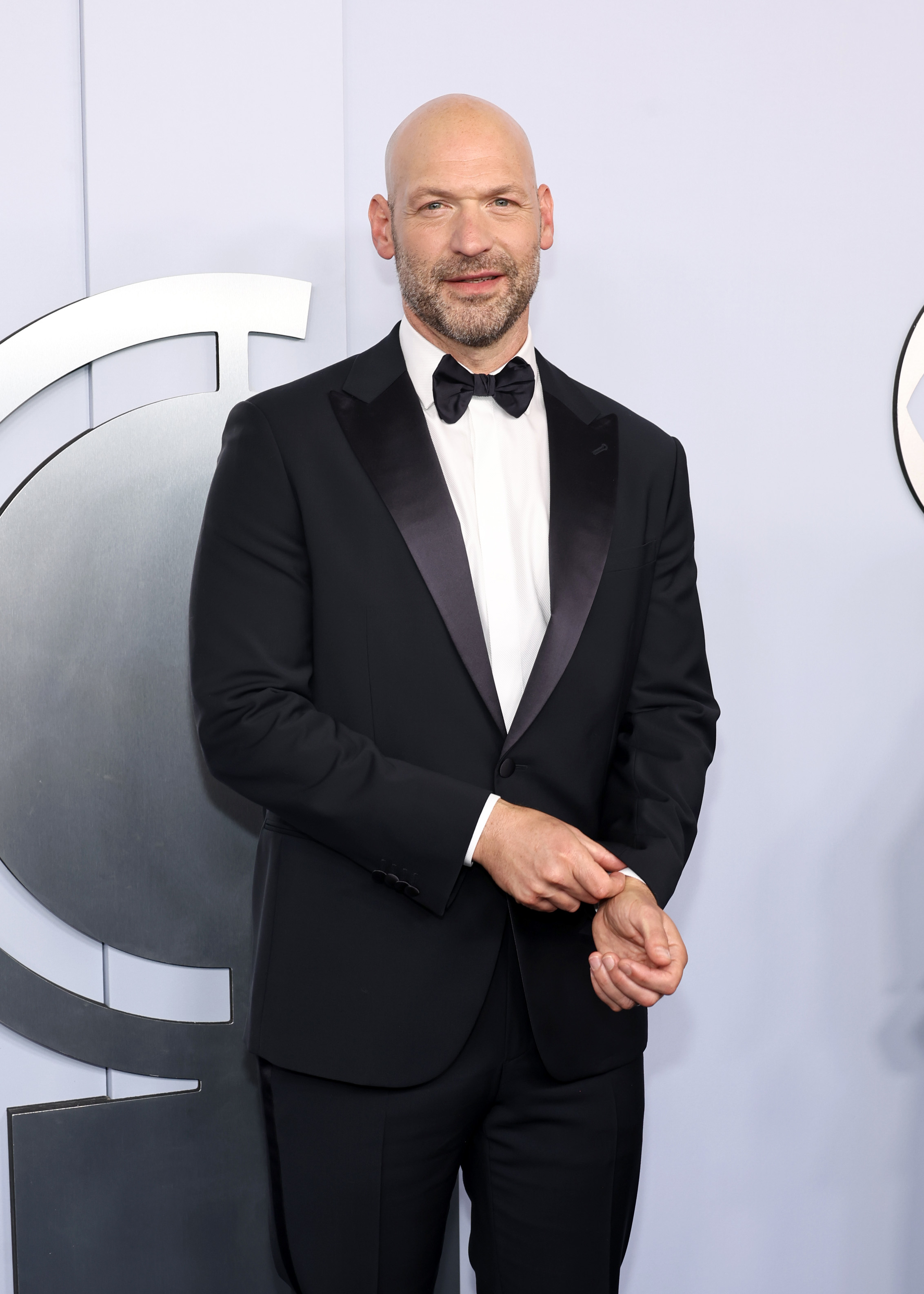 Corey Stoll in a black tuxedo with a bow tie at a formal event