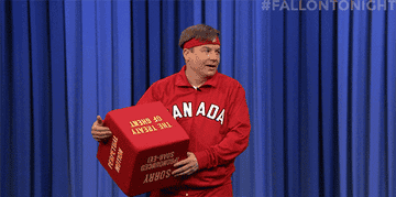 Mike Myers, wearing a Canadian tracksuit and headband, humorously holding a large red die labeled &quot;SORRY,&quot; on &quot;The Tonight Show Starring Jimmy Fallon.&quot;