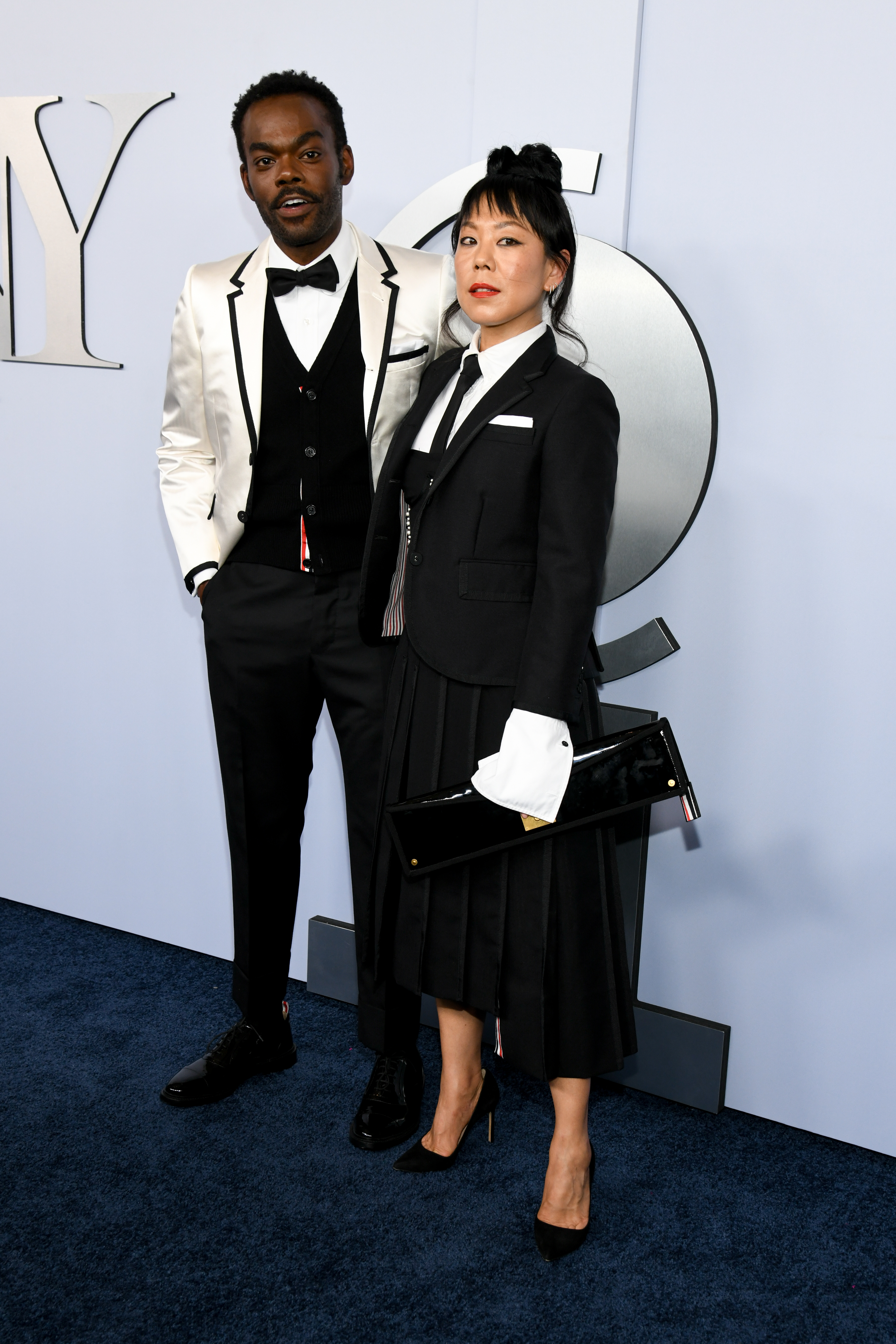 William Jackson Harper and Ali Ahn pose together in black and white formal attire at an event