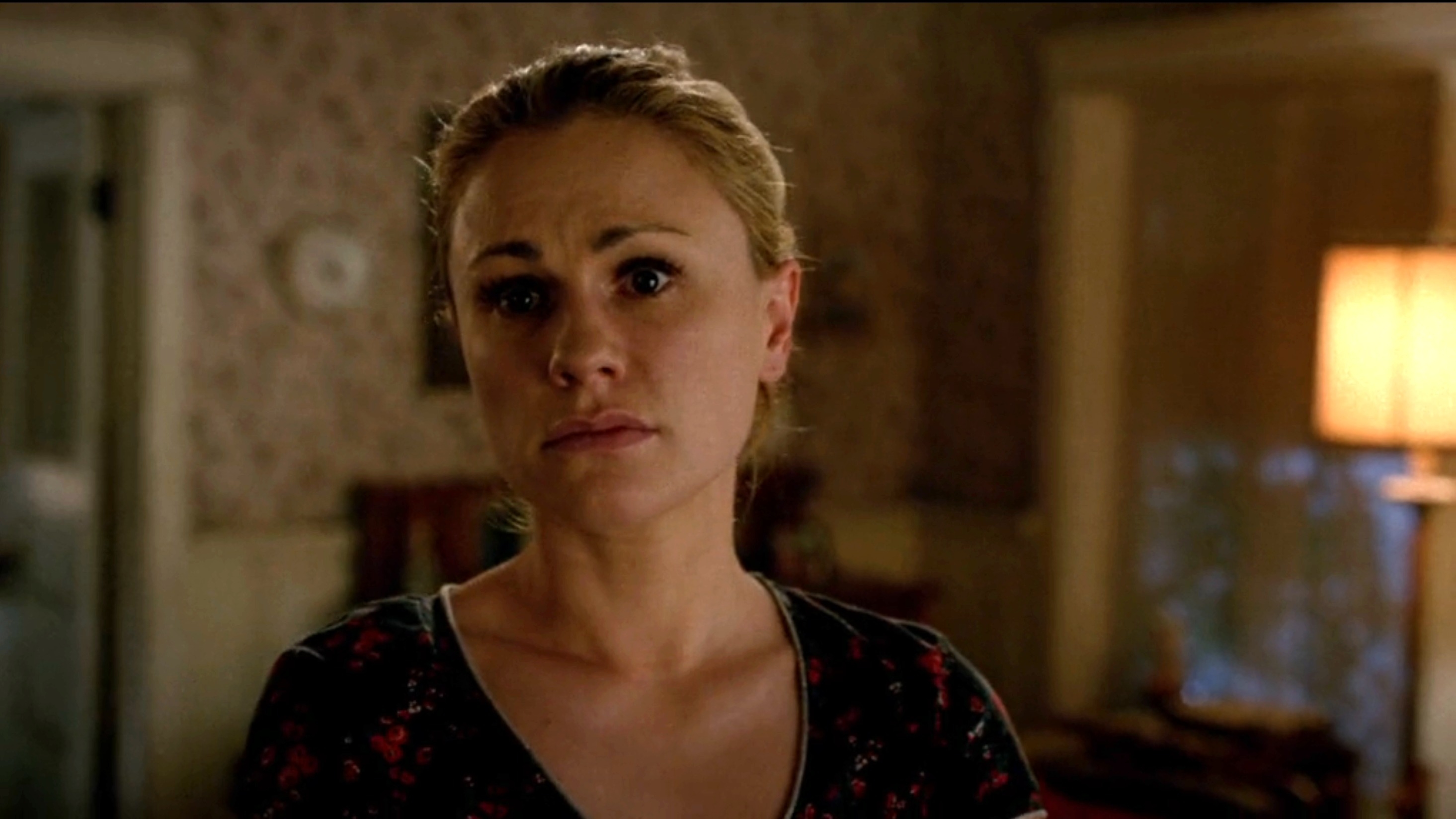 Anna Paquin in a somber scene from &quot;True Blood,&quot; wearing a patterned top and looking emotionally distressed in a dimly lit room