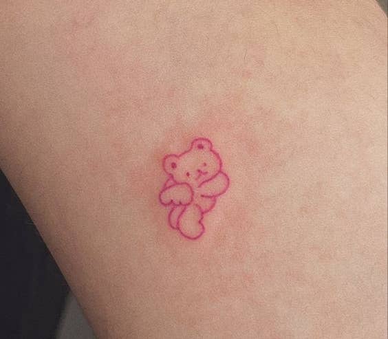 Tatuaje pequeño y detallado de un osito en el brazo de una persona