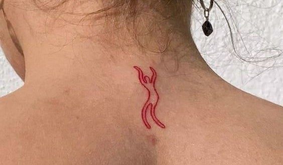 Tatuaje en la parte superior de la espalda de una persona. El diseño es de una figura abstracta