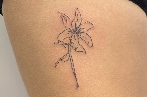 Tatuaje de línea fina de una flor en el brazo de una persona