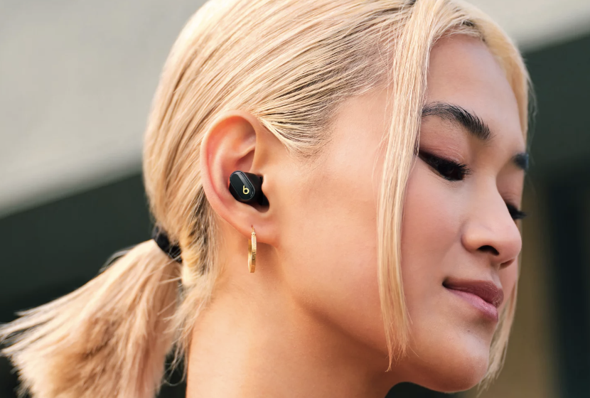 Model wearing Beats Fit Pro earbuds with hair tied back in a ponytail