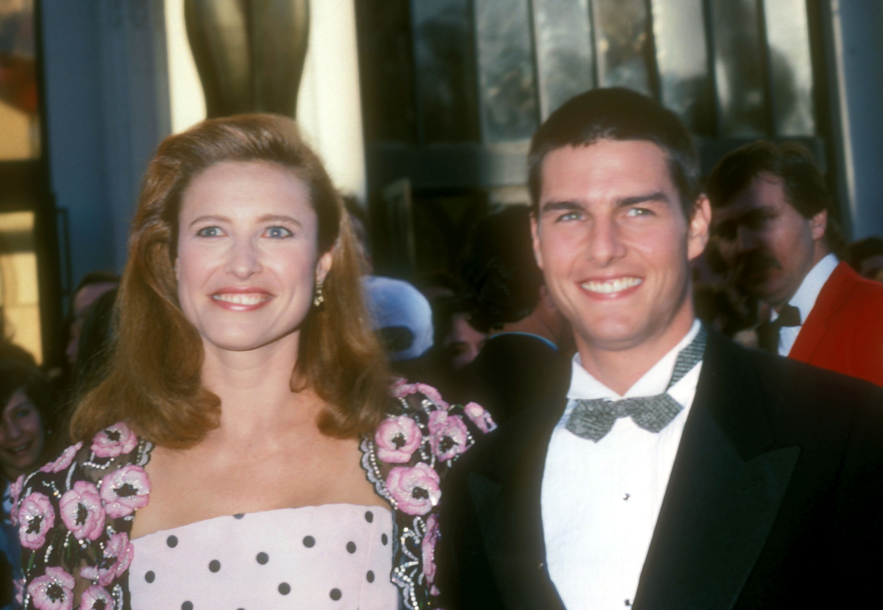 Mimi and Tom Cruise are dressed in formal attire, smiling for the camera at what appears to be a red carpet event