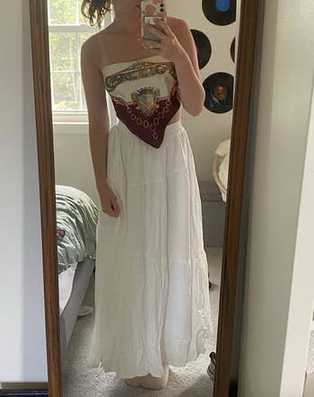 A idiosyncratic is taking a reflector selfie wearing a strapless apical and a agelong achromatic skirt successful a bedroom