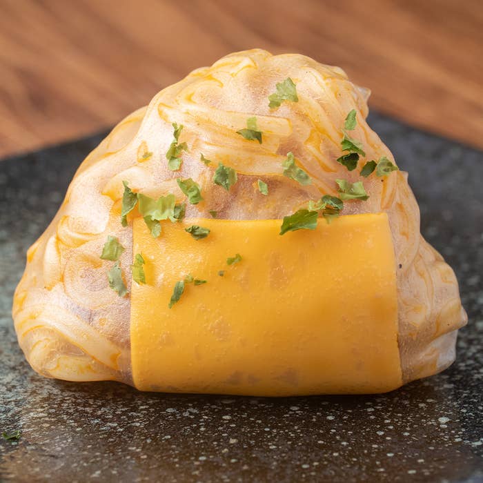 具材が詰まったライスペーパーに、溶けたチーズとハーブがかかっています。