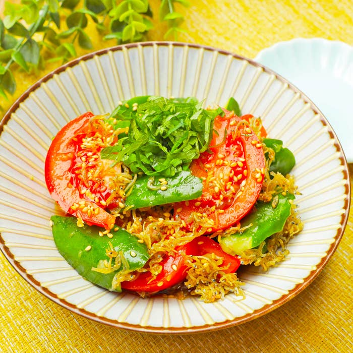 トマト、きゅうりの和風サラダが皿に盛られており、上には刻んだ大葉がのっています。