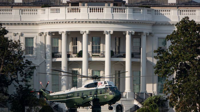 A helicopter marked &quot;United States of America&quot; is landing on the lawn in front of the White House