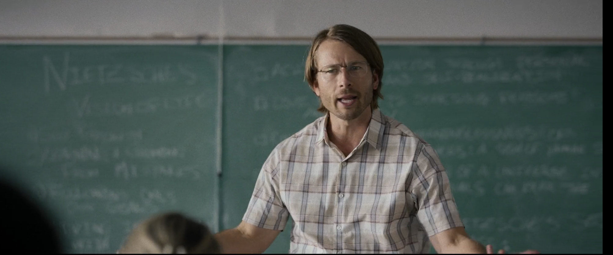 Glenn Powell as Gary Johnson teaching a course.