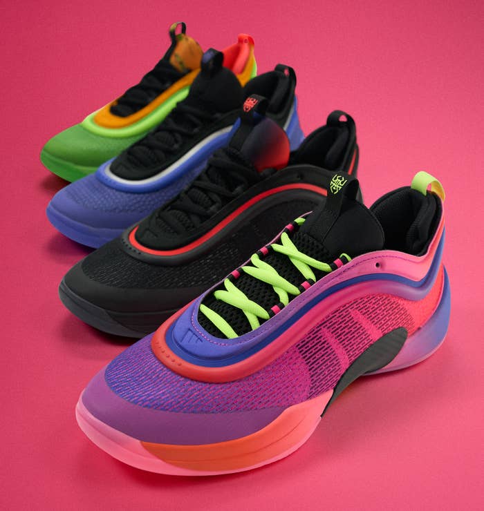 Four pairs of stylish sneakers with a modern design are arranged in a row on a solid background, showcasing various vibrant color schemes