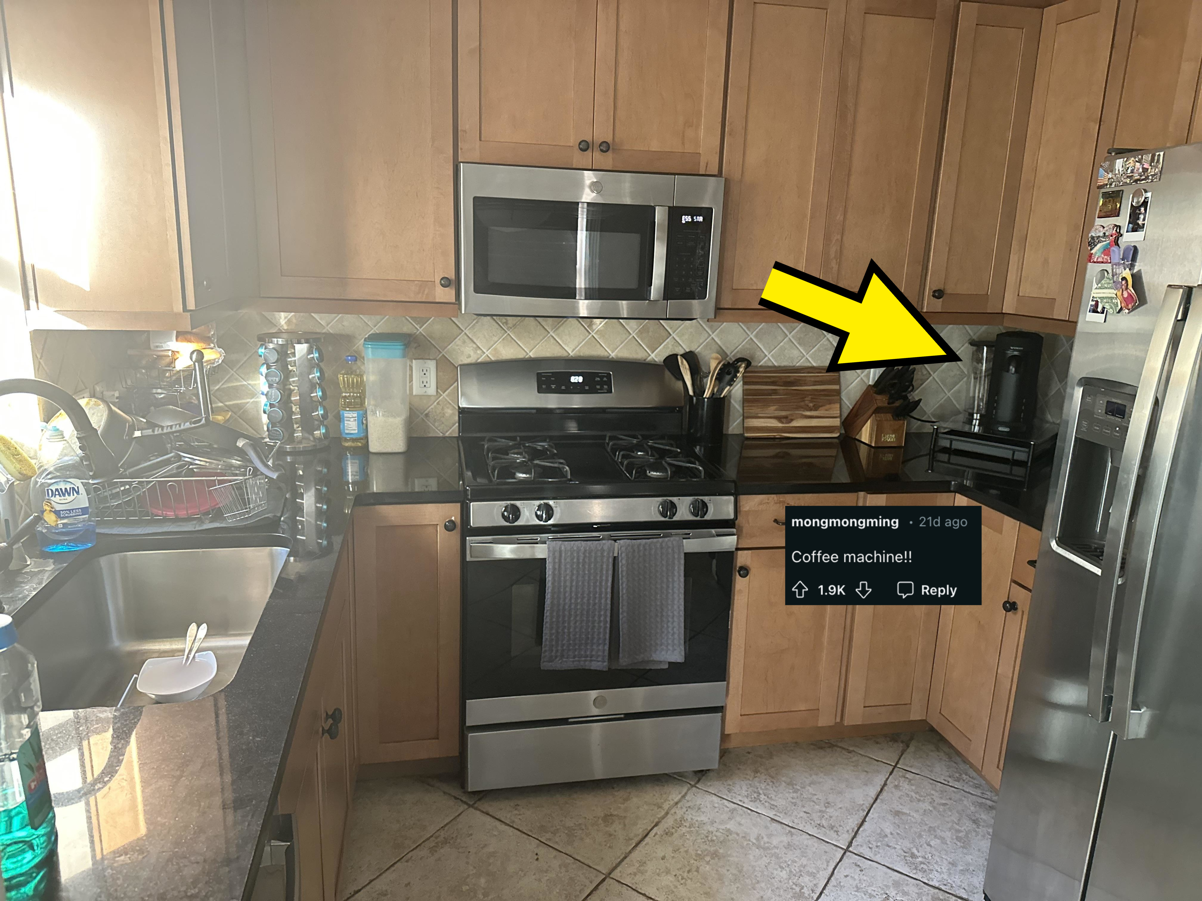 Modern kitchen with wooden cabinets, stainless steel appliances, a sink with dishes, a stove with hanging towels, and a fridge with magnets