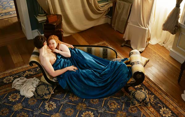 Nicola Coughlan and Luke Newton in &quot;Bridgerton&quot; lying on a chaise lounge during an intimate scene