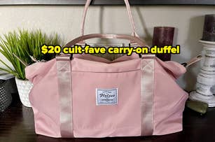 Pink duffel bag with handles on a table, highlighted by text: "$20 cult-fave carry-on duffel."