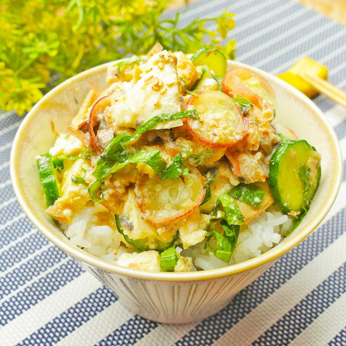 ご飯の上にキュウリやその他の野菜がのったヘルシーな料理。