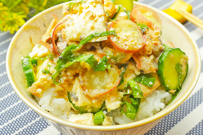 ご飯の上にキュウリやその他の野菜がのったヘルシーな料理。