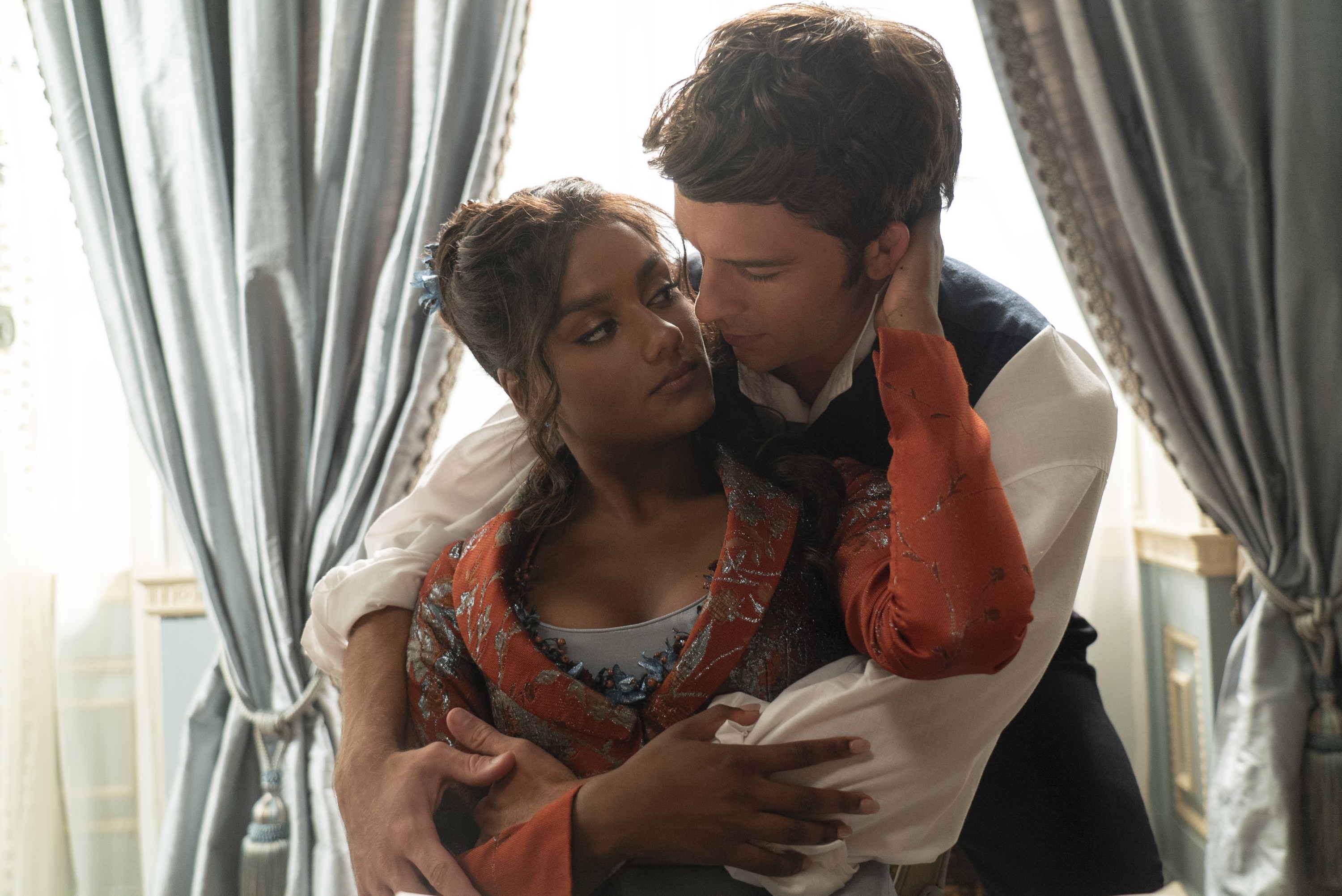 Simone Ashley and Jonathan Bailey as Kate and Anthony embrace tenderly in a scene from the TV series "Bridgerton."