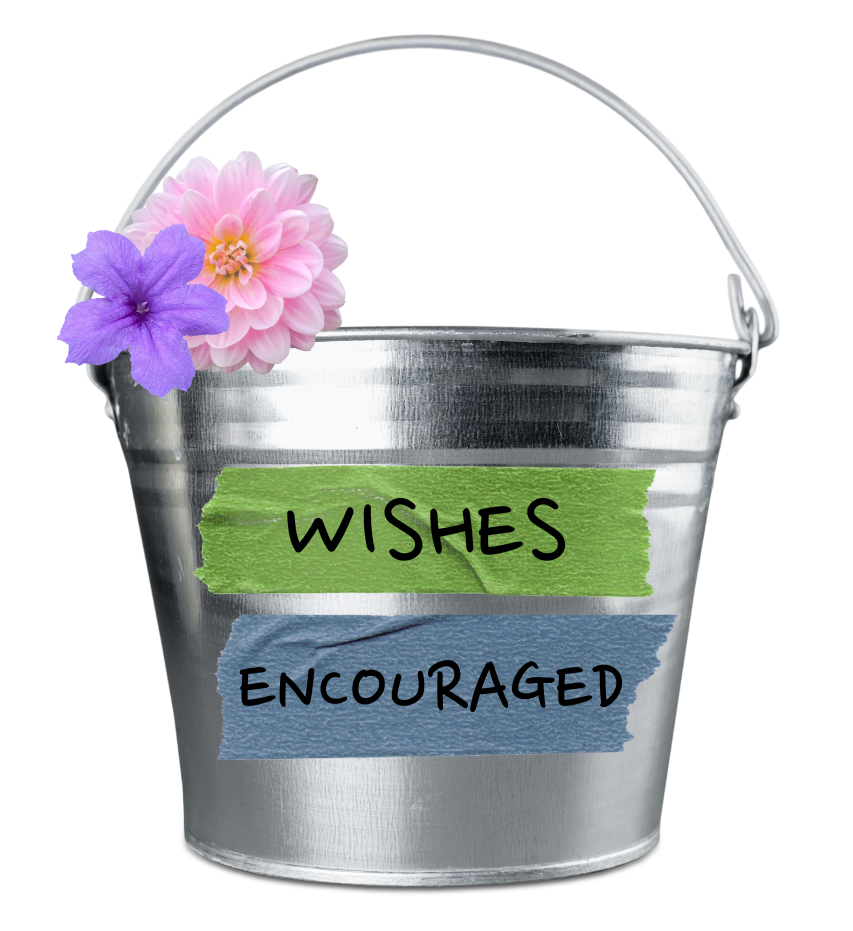 A metal bucket with flowers attached on the side and text saying &quot;Wishes Encouraged.&quot;