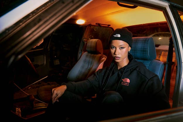 A woman in a beanie and casual attire sits inside a car