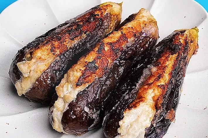 3本の焼きナスが白い皿に盛られています。