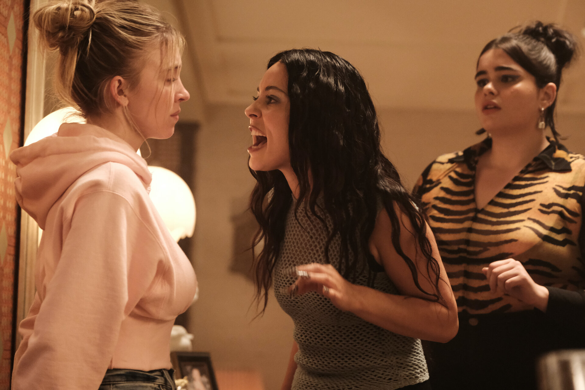 Sydney Sweeney, Alexa Demie, and Barbie Ferreira in a heated conversation scene. Sweeney wears a hoodie, Demie a mesh top, and Ferreira a tiger print blouse