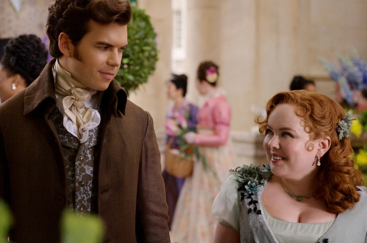 Luke Newton and Nicola Coughlan in Regency-era attire at a formal event in a scene from Bridgerton