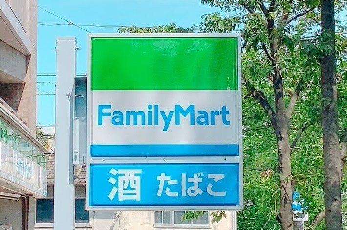 FamilyMartの看板、下に「酒 たばこ」の文字。周囲は緑が多い街並み。