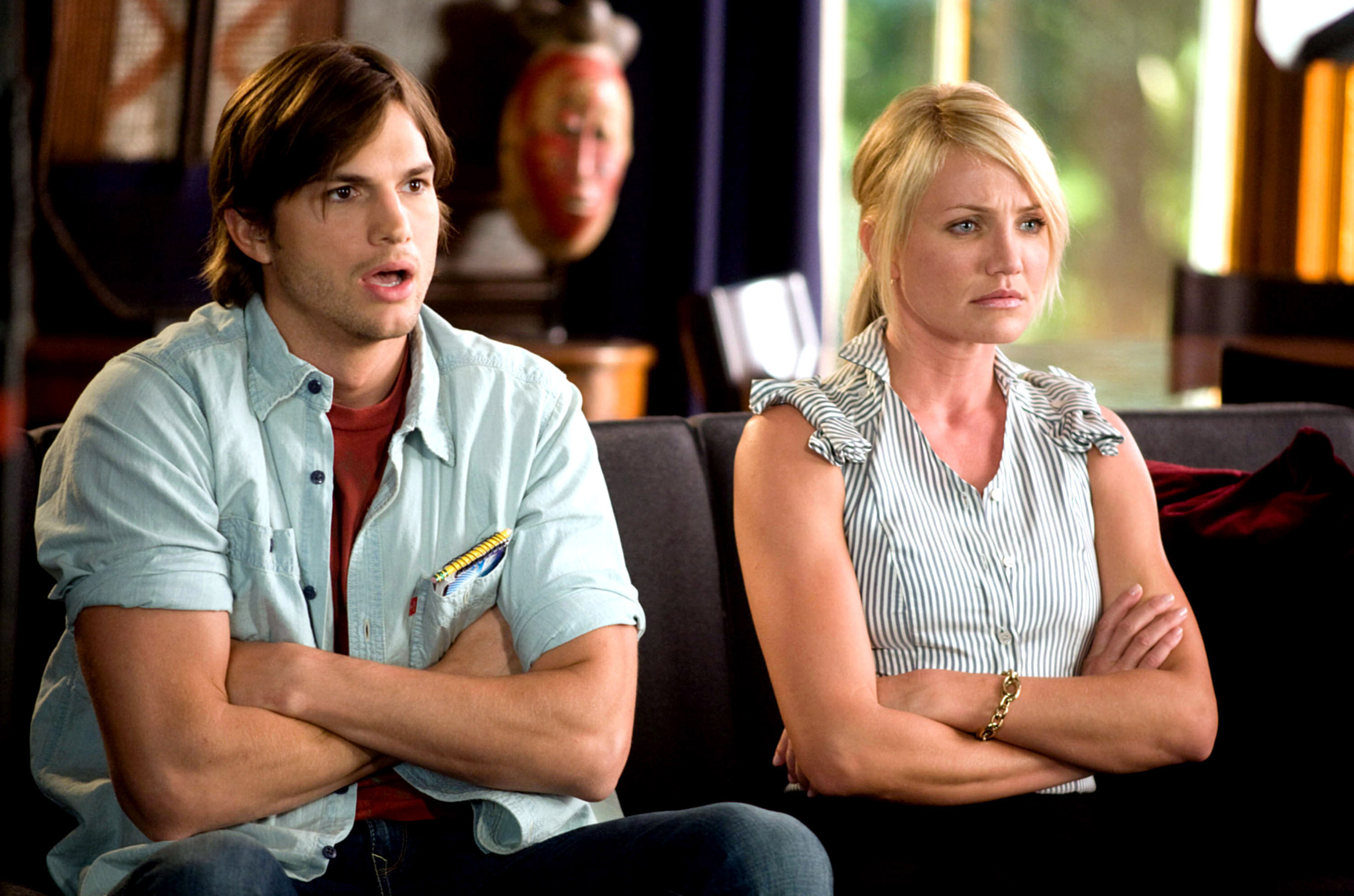 Ashton Kutcher and Cameron Diaz, sitting on a couch with arms crossed, looking serious in a scene from &quot;What Happens in Vegas&quot;