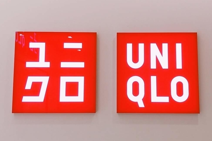 ユニクロの赤い看板が2つ並んでいる様子。左はカタカナで「ユニクロ」、右は英語で「UNIQLO」と書かれています。
