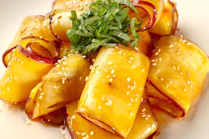 ゴマがまぶされたナスとエビロールの料理。上には刻んだ青じそがのせられている。