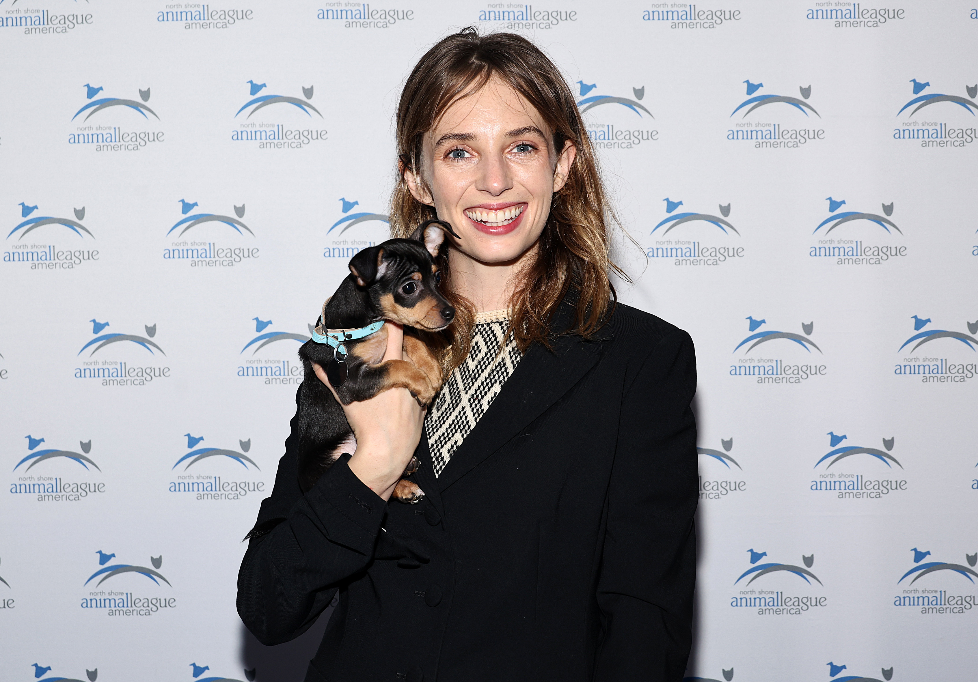 Closeup of Maya Hawke holding a puppy