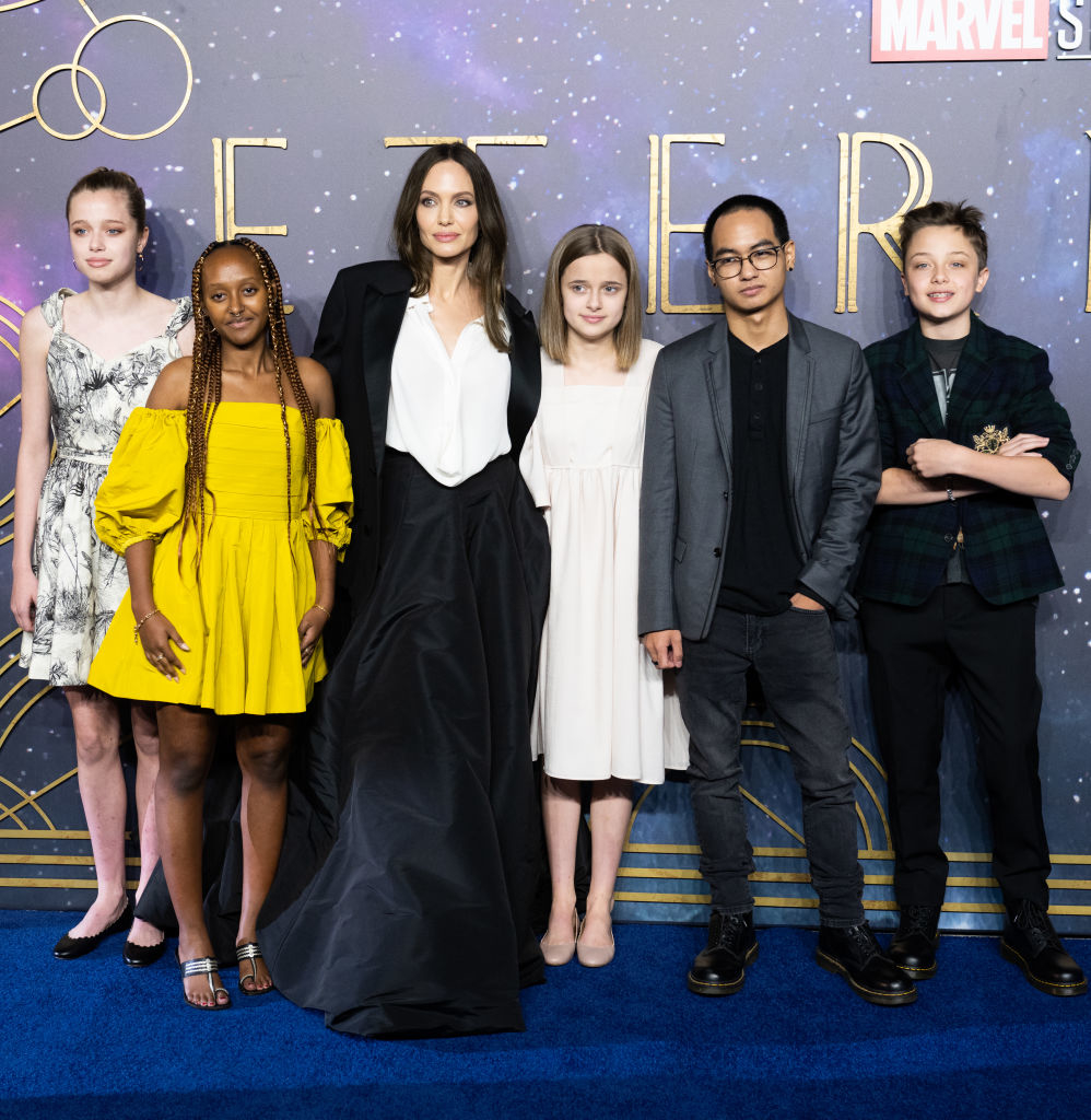 Angelina Jolie wearing a black gown with her children Shiloh, Zahara, Vivienne, Maddox, and Knox at the "Eternals" premiere