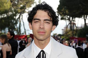 Joe Jonas on the red carpet wearing a suit with a bolo tie