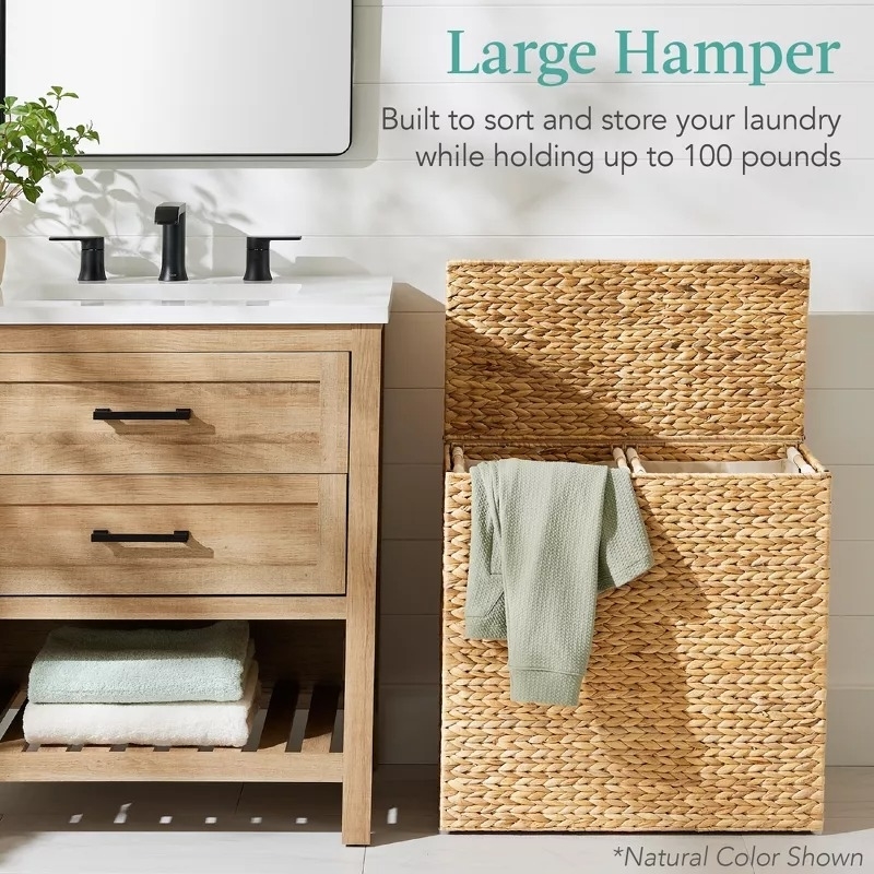A large hamper beside a bathroom vanity with towels and other small items. The hamper is designed to hold up to 100 pounds of laundry