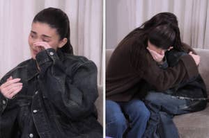 Kylie Jenner and Kendall Jenner sitting on a couch; Kylie is emotional and Kendall is comforting her with a hug. Both are wearing casual outfits