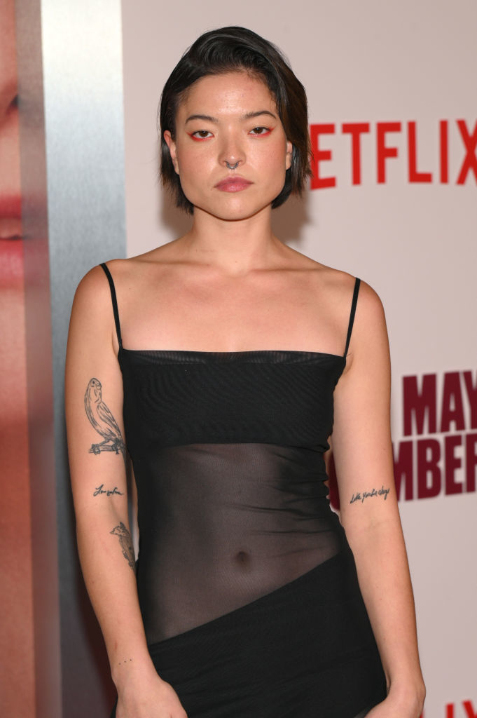 Piper in a sleek dress poses on the red carpet at a Netflix event for &quot;May December.&quot; Tattoos are visible on her arms