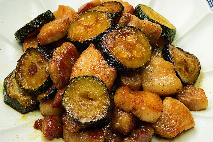白い皿に盛り付けられた鶏肉とズッキーニの炒め物。