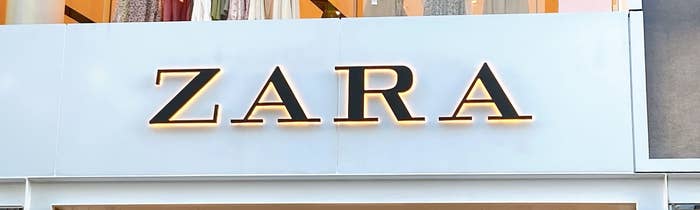 Zara storefront with clothing displayed on upper level racks