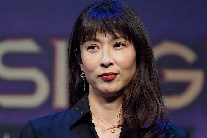 女優の天海祐希がトークイベントで黒いシャツを着てマイクを持っている。