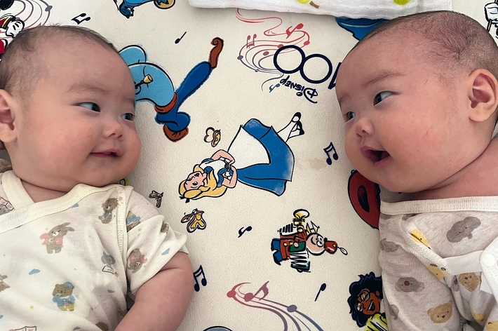 2人の赤ちゃんがキャラクターデザインのシートの上でお互いを見つめ合っています。