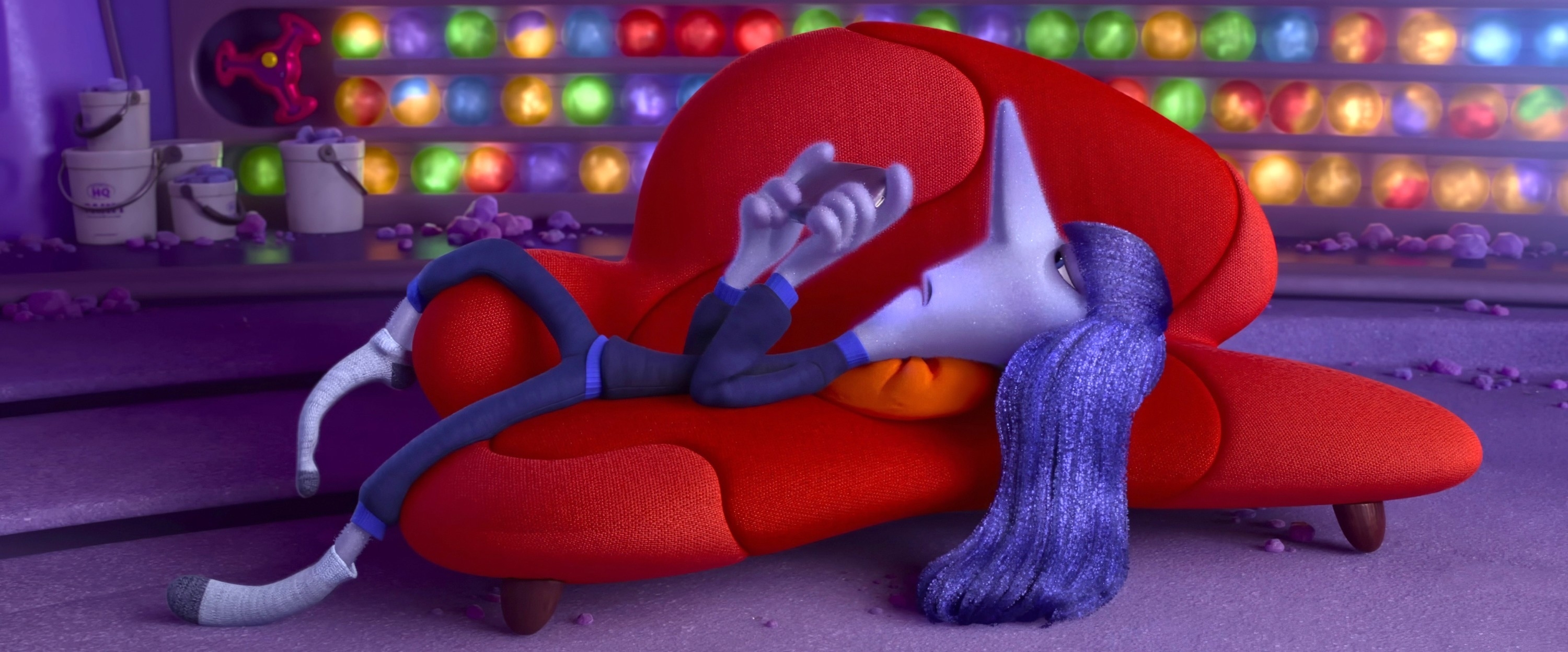 Ennui lounges on a couch looking at a device
