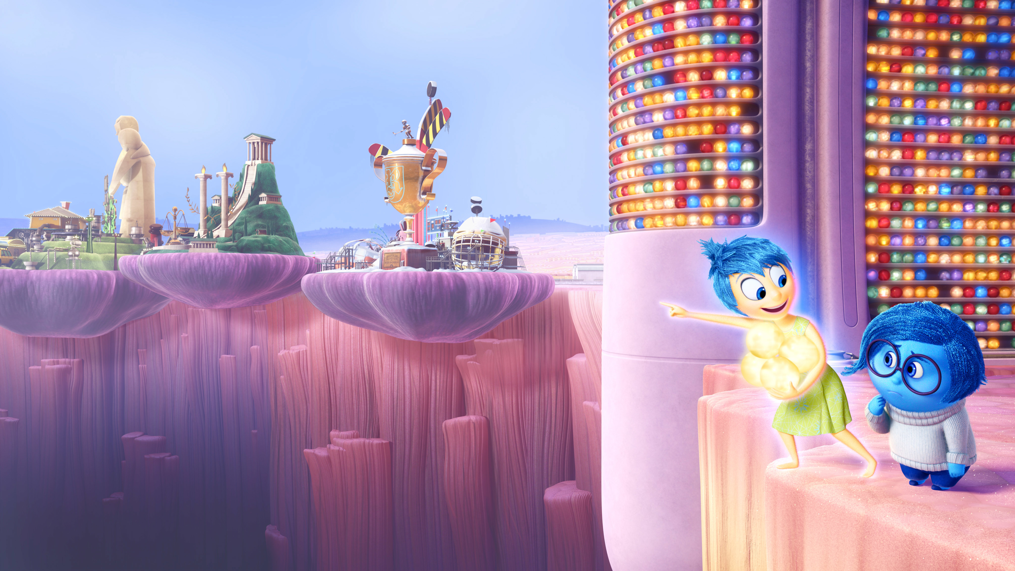 Joy and Sadness stand on a platform overlooking the landscape of Riley's mind, with bright orbs and islands visible in the background