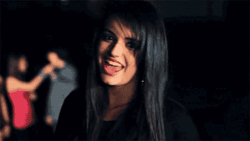 Rebecca Black sings and dances in a music video with people in the background