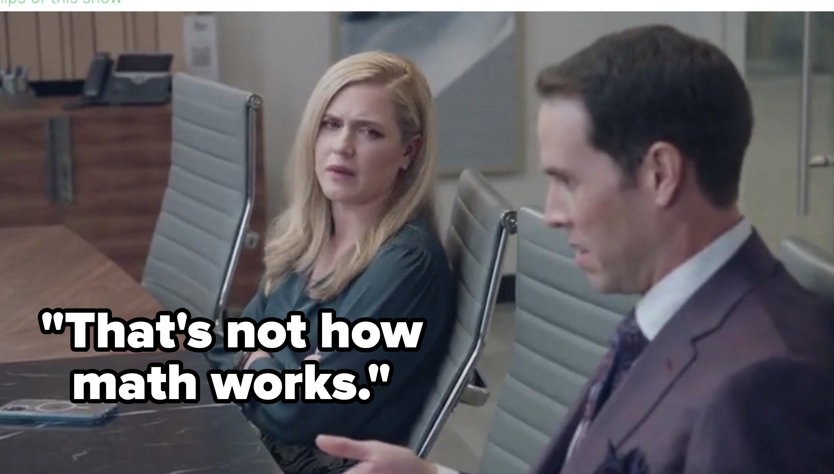 Two people, Ana Gasteyer and Jon Barinholtz, sit in a boardroom discussing during a scene from the show &quot;American Auto&quot; (S01E07)