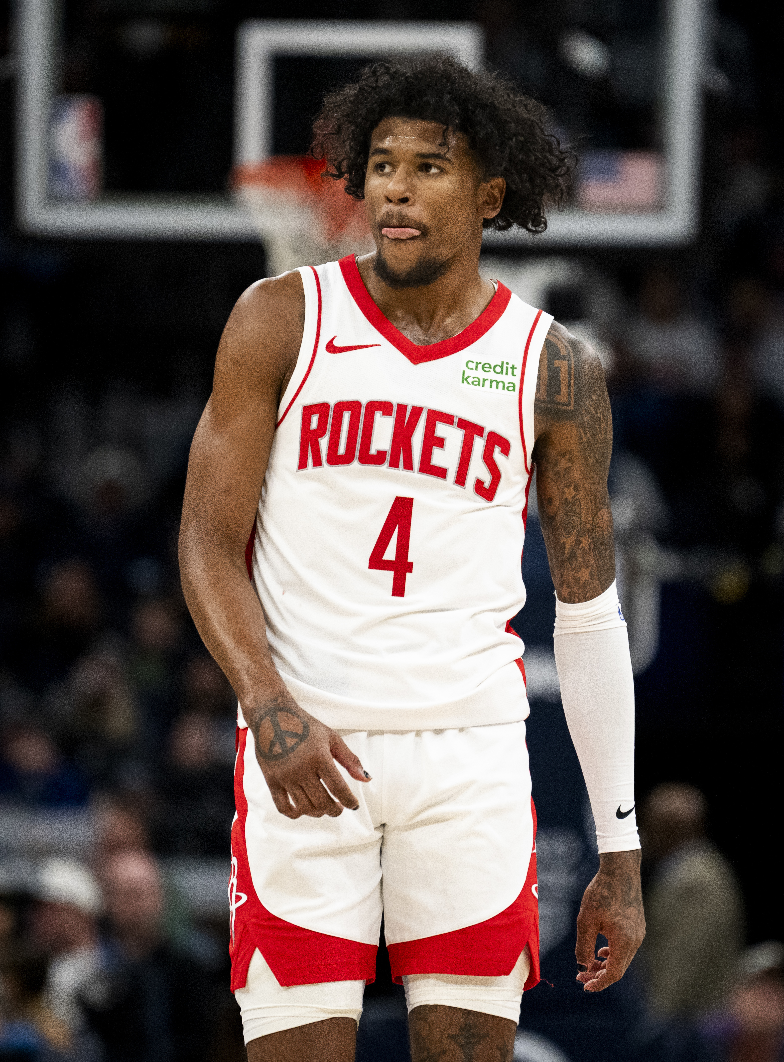 Basketball player Jalen Green in a white and red "Rockets" uniform, standing on a court