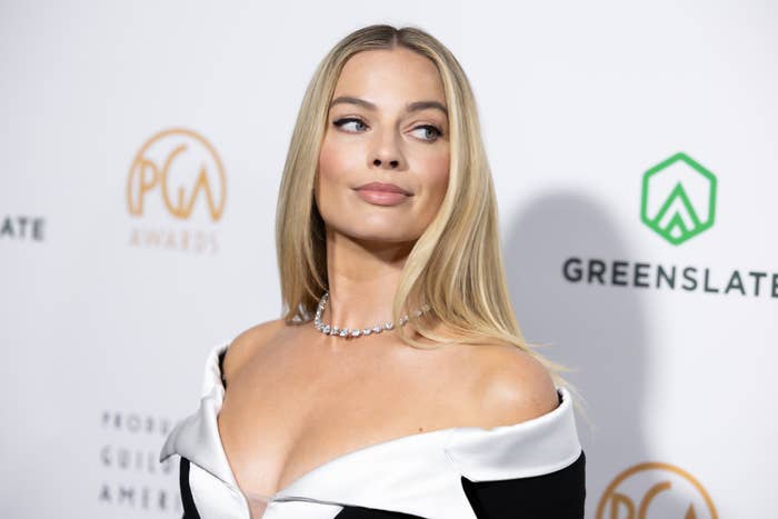 Margot Robbie on the red carpet at the Producers Guild of America Awards, wearing an off-the-shoulder two-toned gown with a diamond necklace