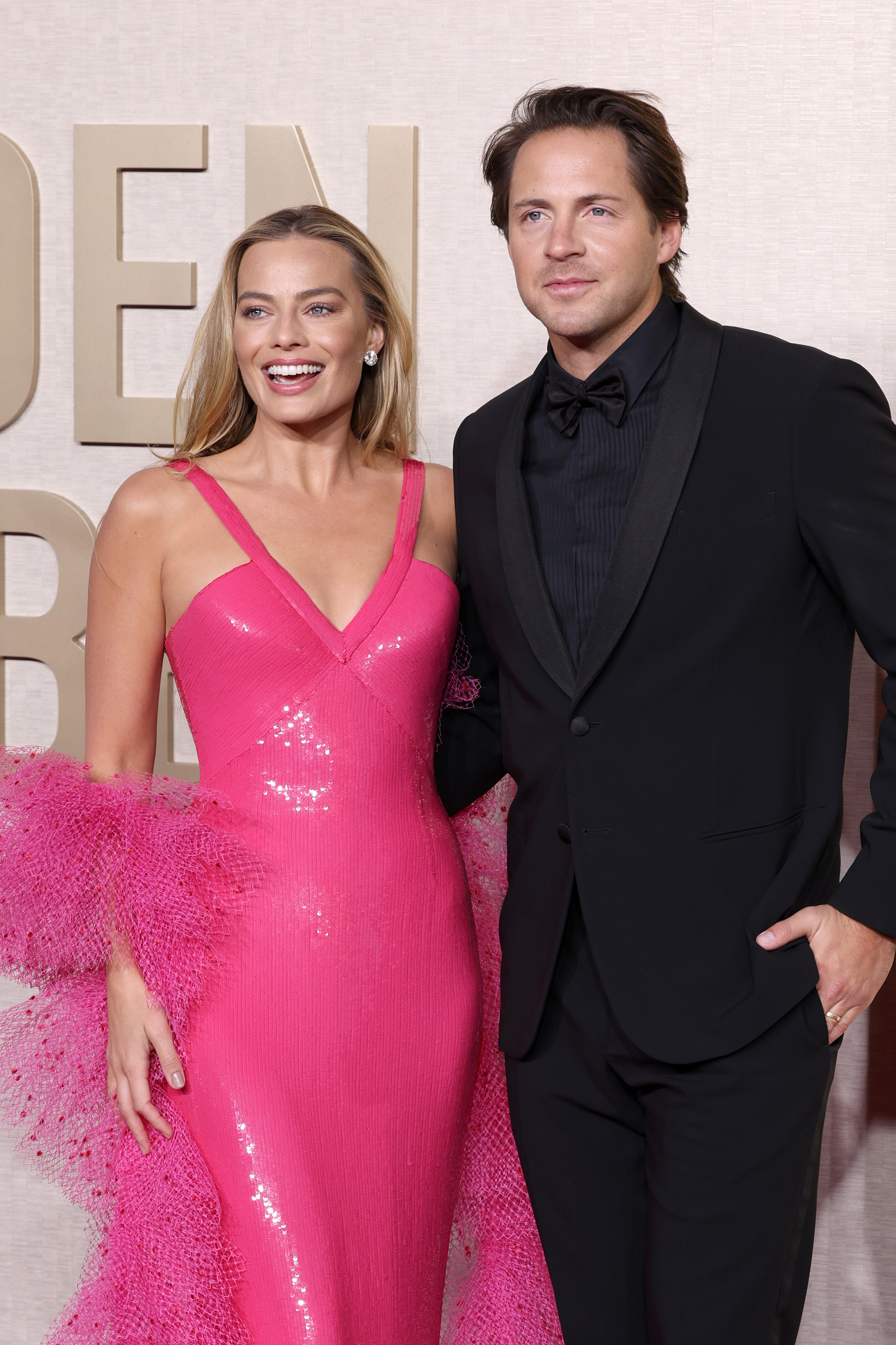 <b>Margot</b> <b>Robbie</b> in a shimmering pink dress with a tulle stole and Tom Ackerle...