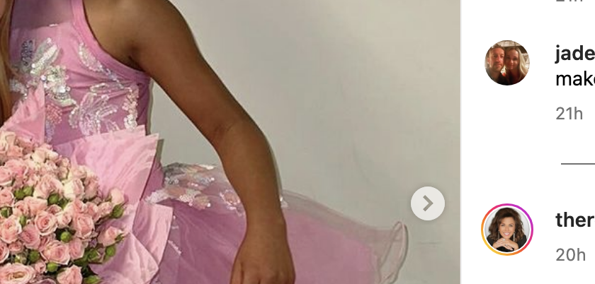 Khloé Kardashian kneels beside her daughter True, who is dressed in a pink ballet outfit, holding a bouquet of flowers. They are both smiling at the camera