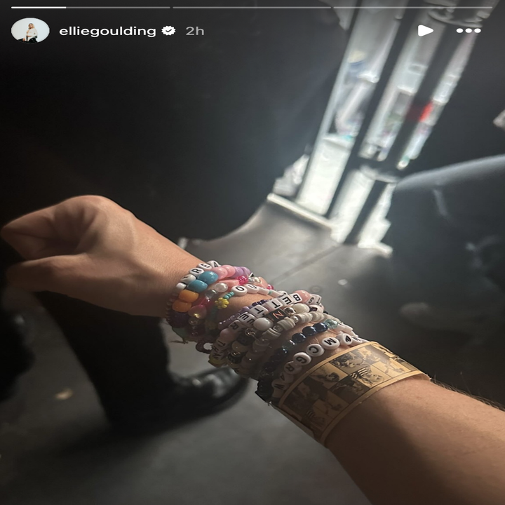Ellie Goulding showing off her friendship bracelets at a Taylor Swift concert